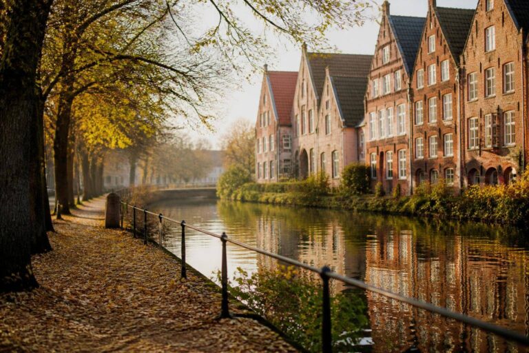 Uferweg an einem Fluss mit Backsteingiebeln im Herbstlicht – Personal Trainer in Lüneburg finden